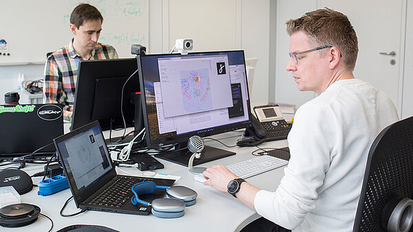 Photo of Dennis Hoppe and colleague at work in HLRS offices.