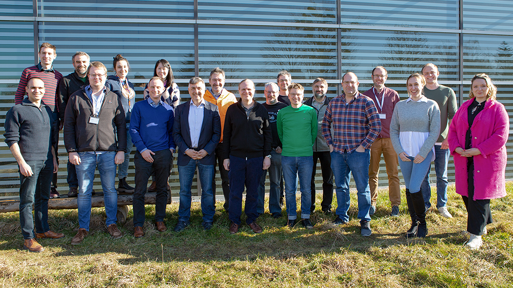 Group photo of 19 people in front of the HLRS building.